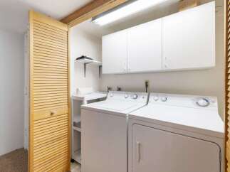 This laundry room features a stacked washer and dryer for efficient use of space.