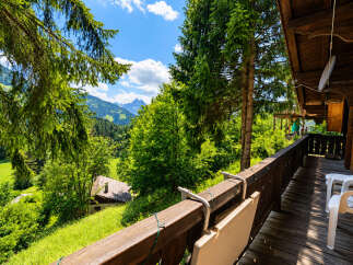 Experience breathtaking mountain views from the expansive wooden balcony of this charming alpine property.