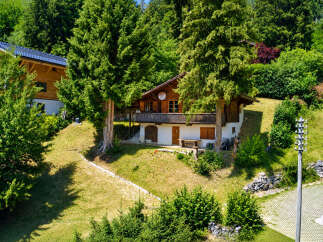 Nestled amidst lush greenery, this charming chalet offers a serene mountain retreat.