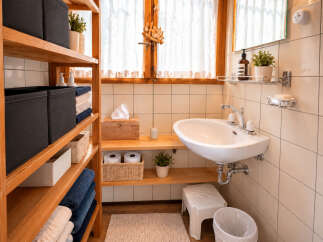 This bathroom features a charming wooden shelving unit providing ample storage for towels and baskets.