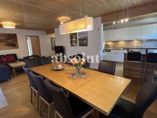 This spacious open-plan living area features a modern kitchen with ample counter space and a breakfast bar, perfect for entertaining.