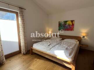 Experience comfort and style in this beautifully appointed bedroom, featuring a spacious wooden bed and soft, ambient lighting.