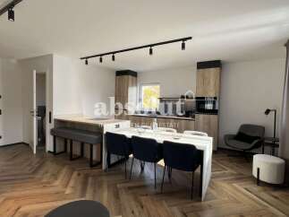 Experience modern living in this beautifully designed open-plan space, featuring a sleek kitchen with integrated appliances and ample cabinetry.