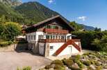 Nestled against a majestic mountain backdrop, this charming chalet offers a quintessential alpine retreat.