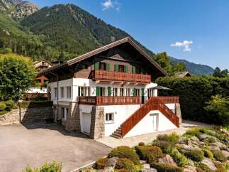 Nestled against a majestic mountain backdrop, this charming chalet offers a quintessential alpine retreat.