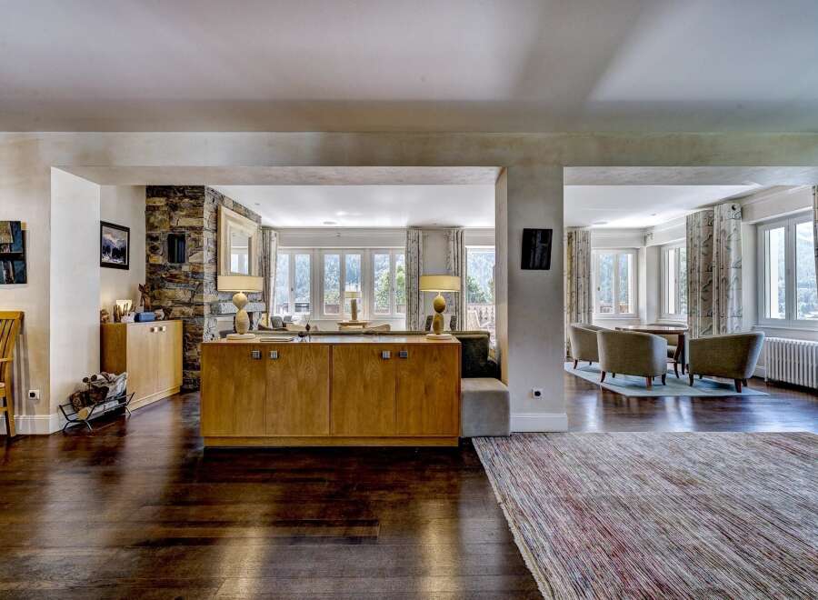 Experience luxurious living in this spacious open-plan interior, featuring a stunning stone accent wall and elegant wooden cabinetry.