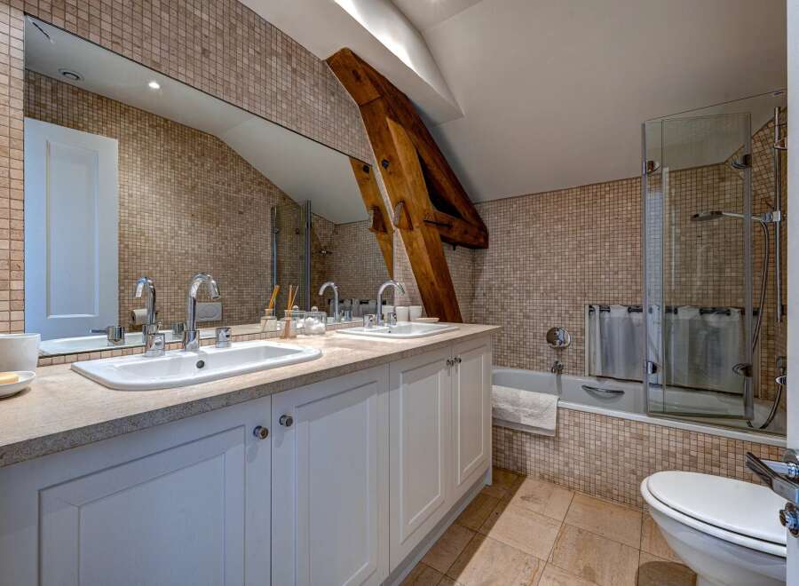 This charming bathroom features a spacious double vanity with modern chrome fixtures and ample counter space, perfect for busy mornings.