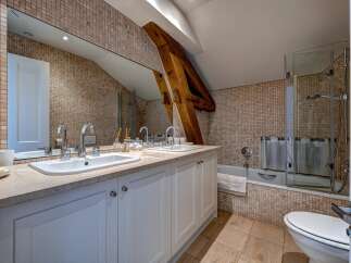 This charming bathroom features a spacious double vanity with modern chrome fixtures and ample counter space, perfect for busy mornings.