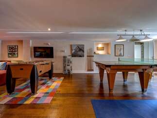 This spacious game room offers endless entertainment with a foosball table and a pool table, perfect for friendly competition.