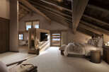 Experience luxurious mountain living in this stunning attic bedroom, featuring exposed wooden beams and a cozy, plush carpet.