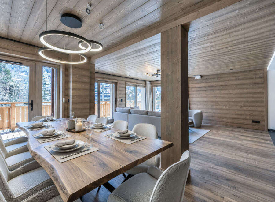 Experience luxurious alpine living in this stunning dining area, featuring a live-edge wooden table perfect for intimate gatherings.