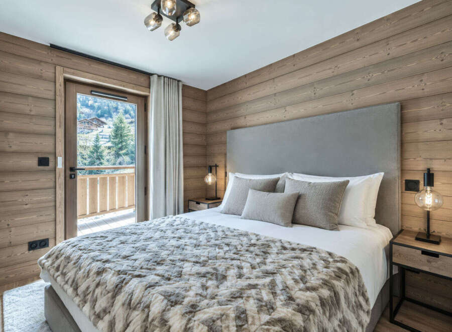 Experience luxurious mountain living in this beautifully appointed bedroom, featuring a plush king-size bed adorned with a cozy, textured throw.