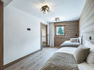 Experience cozy mountain living in this charming bedroom featuring two comfortable beds, perfect for families or guests.