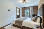 Experience ultimate comfort in this luxurious bedroom, featuring a plush king-size bed adorned with soft linens and decorative pillows.