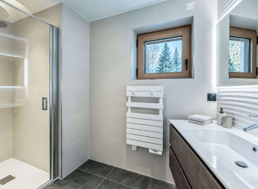 Experience modern luxury in this stunning bathroom, featuring a sleek glass shower enclosure and a spacious vanity with a pristine white sink.