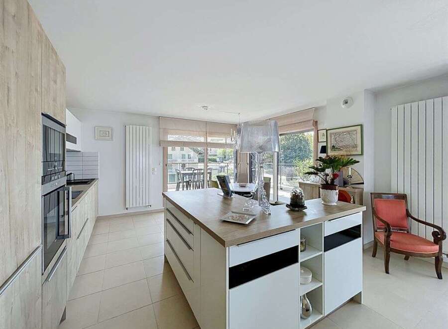 Experience modern living in this spacious kitchen featuring a large island with ample storage and a sleek countertop.