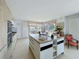 Experience modern living in this spacious kitchen featuring a large island with ample storage and a sleek countertop.
