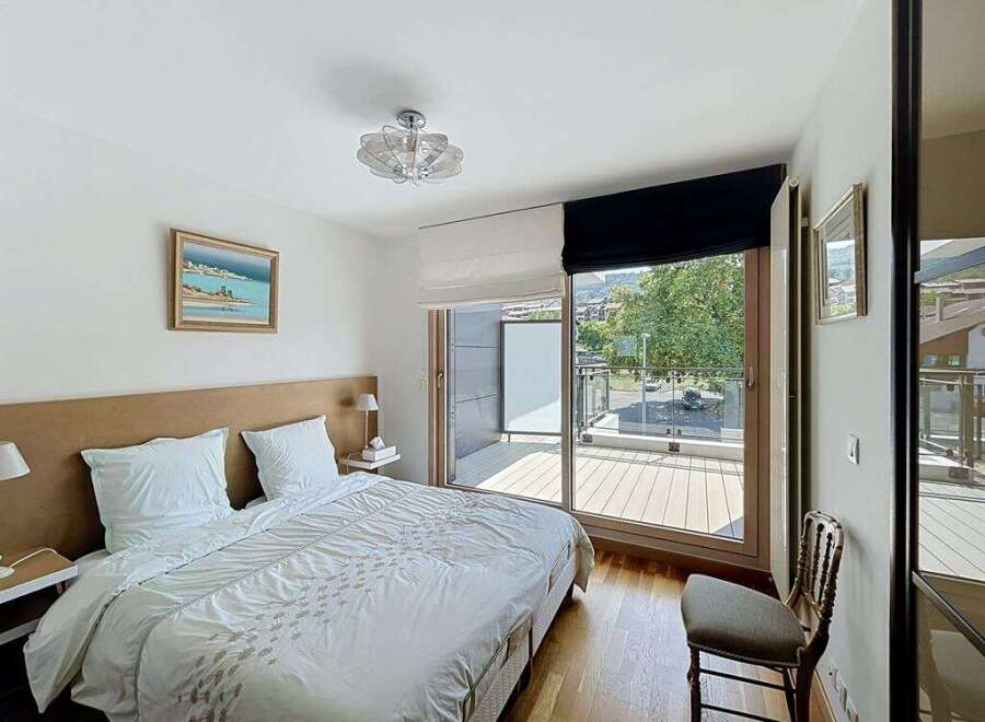 Experience comfort and style in this beautifully appointed bedroom, featuring a plush king-sized bed with crisp white linens and a striking upholstered headboard.