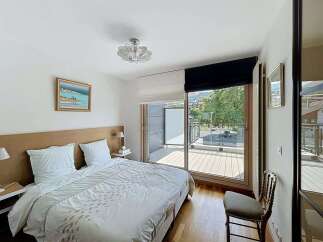 Experience comfort and style in this beautifully appointed bedroom, featuring a plush king-sized bed with crisp white linens and a striking upholstered headboard.