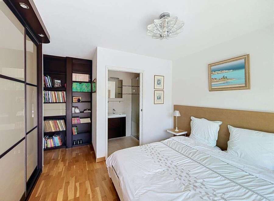 This bedroom offers a serene retreat with a comfortable bed, complemented by a built-in wardrobe and a dedicated bookshelf.