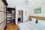 This bedroom offers a serene retreat with a comfortable bed, complemented by a built-in wardrobe and a dedicated bookshelf.