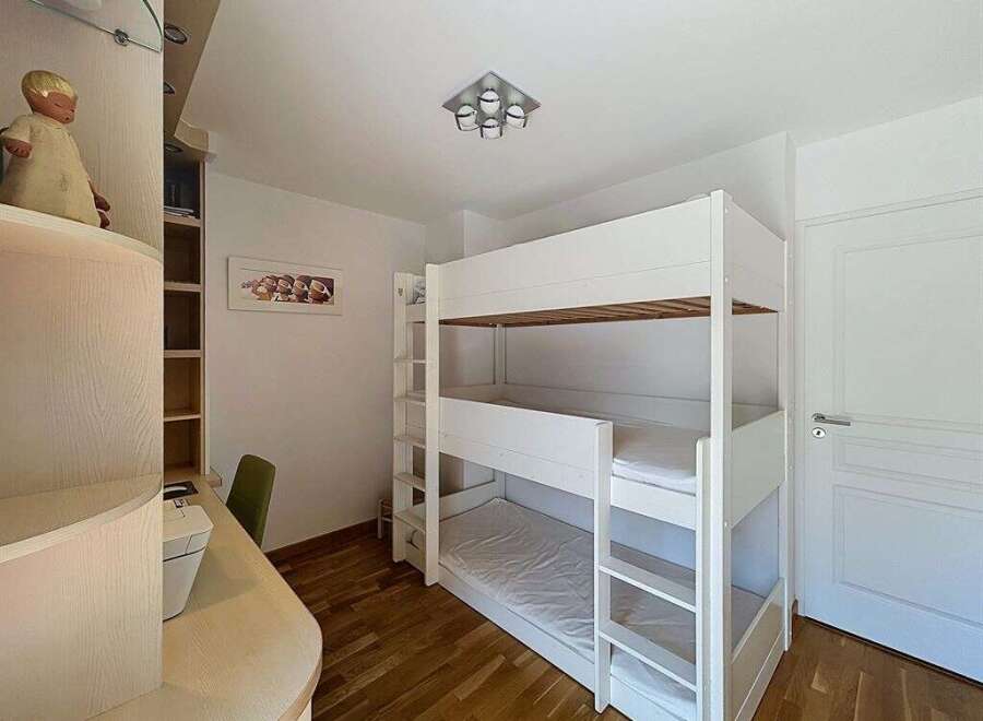 This charming bedroom features a space-saving triple bunk bed, perfect for accommodating multiple guests or children.