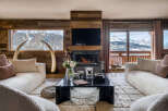 Experience luxurious mountain living in this stunning living room, featuring a cozy fireplace and breathtaking panoramic views of snow-capped peaks.