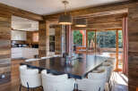Experience luxurious mountain living in this stunning dining area, featuring a spacious dark wood table surrounded by plush white chairs.