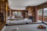 Experience luxury mountain living in this stunning chalet featuring a spacious living area with a cozy fireplace and a billiards table.