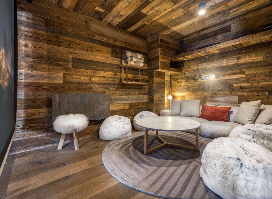 Experience ultimate relaxation in this cozy mountain retreat, featuring a plush sectional sofa adorned with a vibrant orange accent pillow.