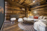 Experience ultimate relaxation in this cozy mountain retreat, featuring a plush sectional sofa adorned with a vibrant orange accent pillow.