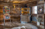 Step into a rustic-chic entertainment haven featuring a vintage pinball machine and a fully stocked bar.