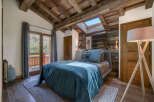 Experience rustic charm and modern comfort in this inviting bedroom, featuring a luxurious bed dressed in serene blue linens.
