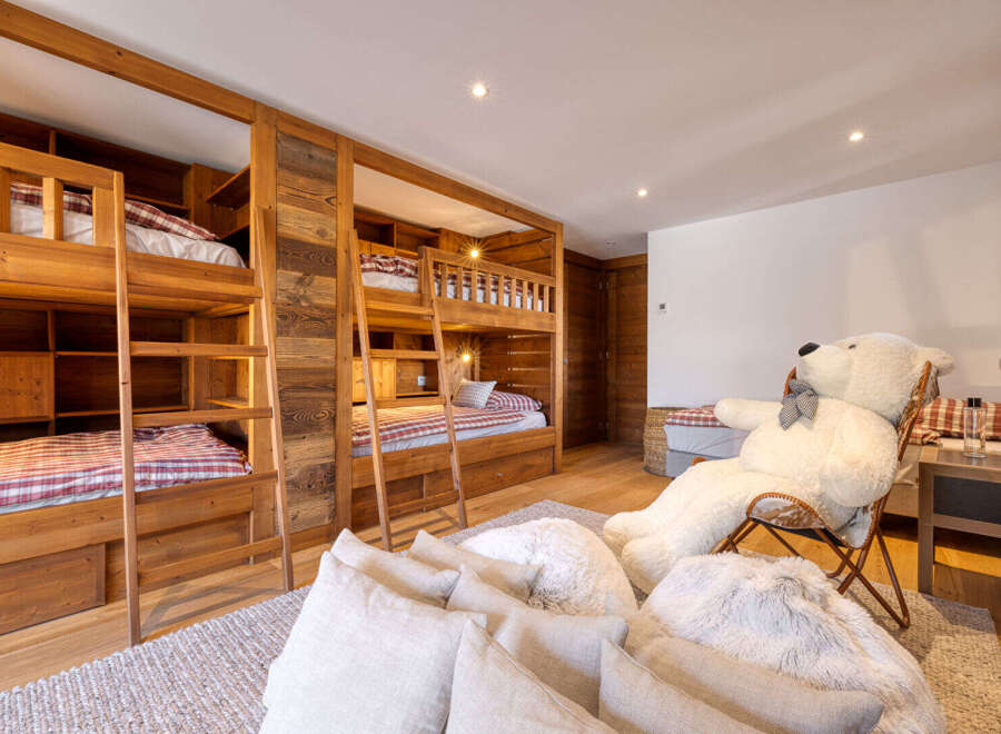 This charming bedroom features multiple wooden bunk beds with plaid bedding, perfect for accommodating family and friends.
