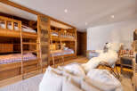 This charming bedroom features multiple wooden bunk beds with plaid bedding, perfect for accommodating family and friends.