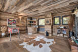 Step into a rustic entertainment haven, featuring a vibrant pinball machine and a fully stocked bar area.