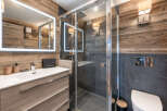 Experience rustic elegance in this modern bathroom, featuring a sleek vanity with ample storage and a large, illuminated mirror.