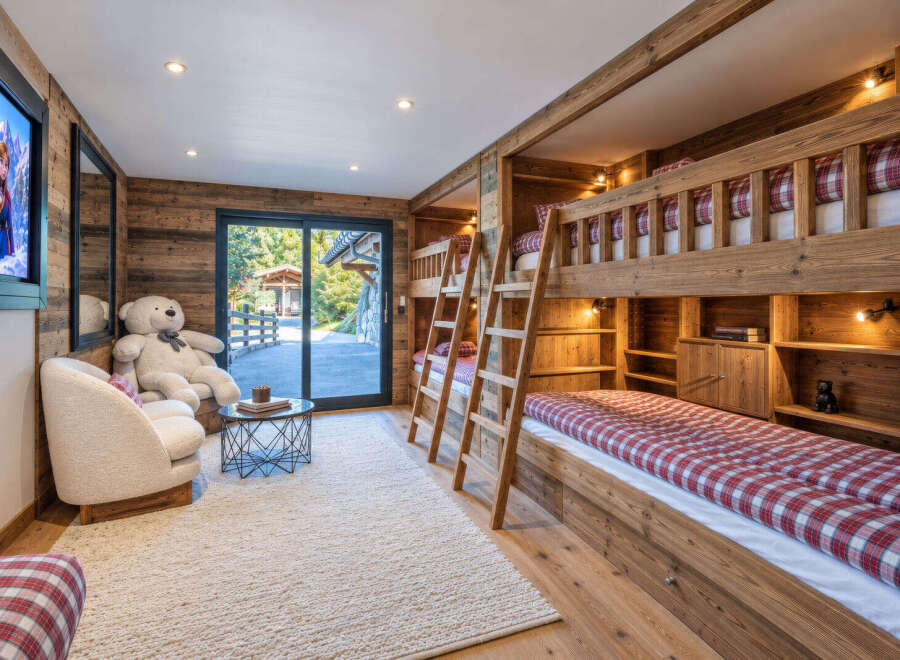 Experience ultimate comfort in this charming children's room, featuring a cozy bunk bed setup with red and white checkered bedding.
