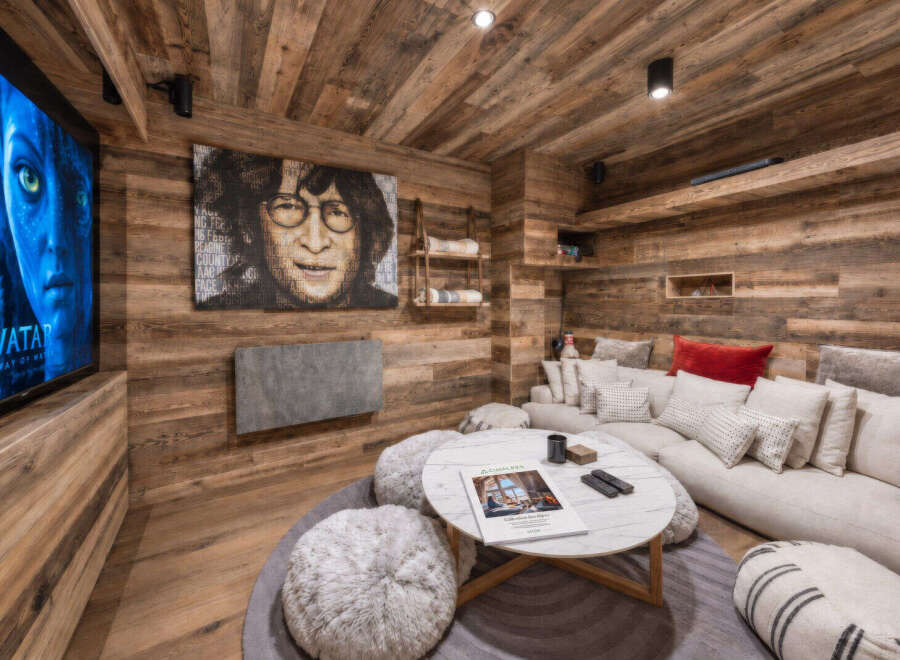 Experience ultimate relaxation in this cozy media room, featuring a large sectional sofa adorned with plush pillows and a stylish marble coffee table.