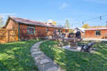 Enjoy outdoor living with this charming backyard featuring a spacious wooden deck, perfect for entertaining.