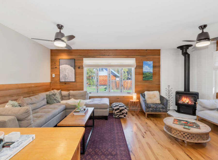 Cozy up by the fire in this inviting living room, featuring a sectional sofa and a stylish armchair.