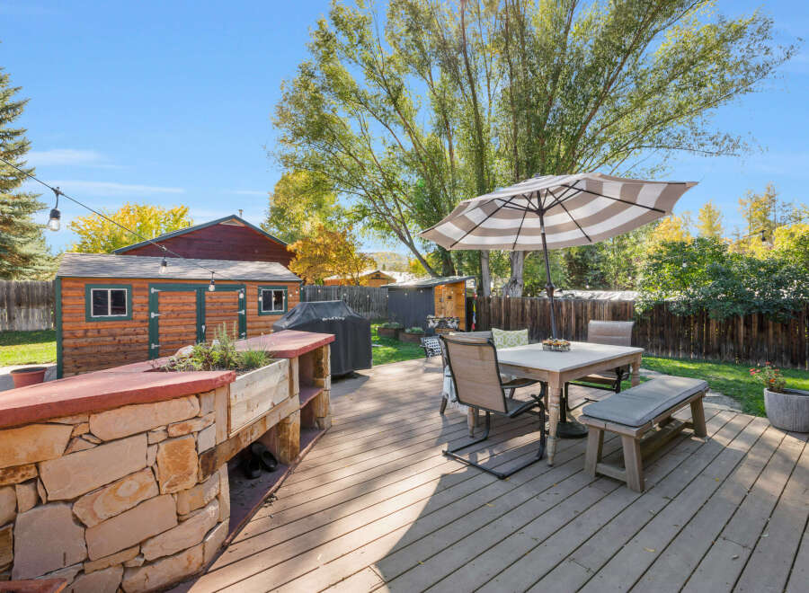 Enjoy outdoor living in this spacious backyard featuring a large wooden deck perfect for entertaining.