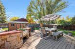 Enjoy outdoor living in this spacious backyard featuring a large wooden deck perfect for entertaining.