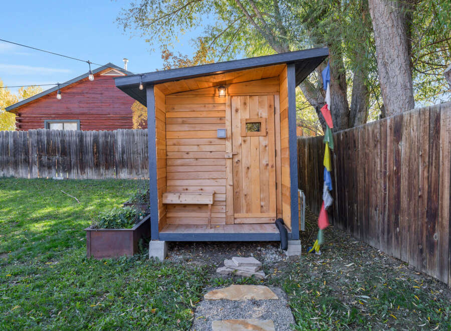 Discover this charming wooden shed, perfect for storage or as a unique backyard retreat.