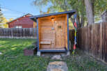 Discover this charming wooden shed, perfect for storage or as a unique backyard retreat.