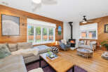 Experience cozy living in this inviting living room, featuring warm wood-paneled walls and a charming fireplace.