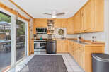 This charming kitchen boasts natural light and ample storage with its beautiful light wood cabinetry.