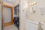 This charming bathroom features a convenient in-unit laundry area with a washer and dryer, perfect for modern living.