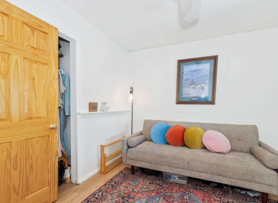 This cozy living space features a comfortable grey sofa adorned with colorful round pillows, perfect for relaxation.