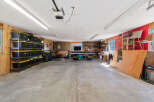 This spacious garage offers ample storage solutions with multiple shelves filled with black and yellow bins, perfect for organizing your belongings.